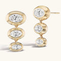 Gold earrings with multiple diamond stones on a white background